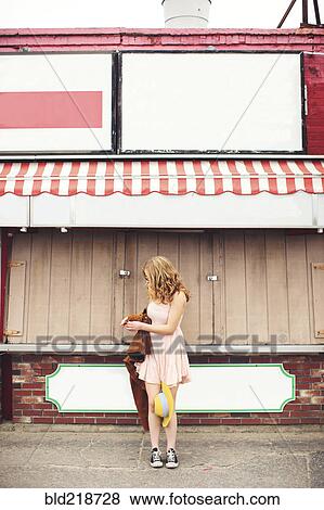 Stock Photo - Caucasian teenage girl standing outside pizzeria. Fotosearch