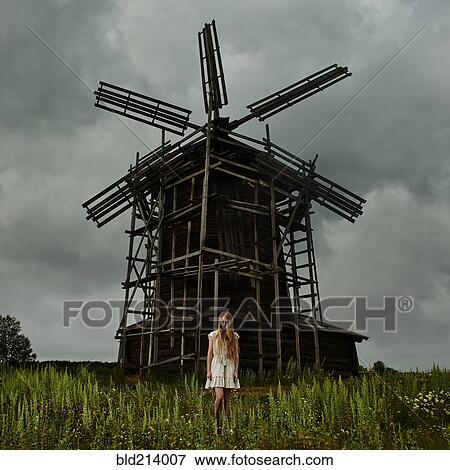 Caucasian teenage girl standing under wooden windmill View Large Photo Image Stock Photo - Caucasian teenage girl standing under wooden windmill. Fotosearch
