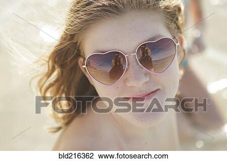 Caucasian teenage girl wearing heart-shaped sunglasses View Large Photo Image Stock Image - Caucasian teenage girl wearing heart-shaped sunglasses. Fotosearch
