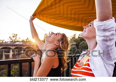 Caucasian teenage girls holding blanket on bridge View Large Photo Image Stock Photo - Caucasian teenage girls holding blanket on bridge. Fotosearch