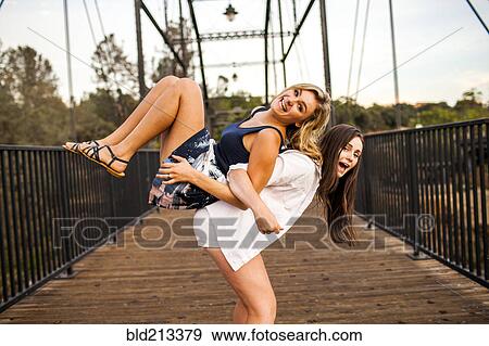 Caucasian teenage girls playing on wooden bridge View Large Photo Image Stock Photo - Caucasian teenage girls playing on wooden bridge. Fotosearch