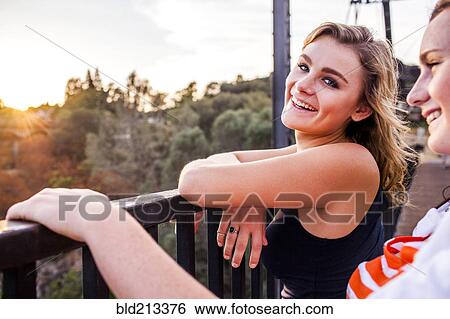 Stock Photograph - Caucasian teenage girls standing on bridge. Fotosearch