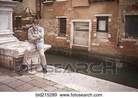 Stock Photo - Caucasian tourist standing on canal waterfront, Venice, Veneto, Italy. Fotosearch