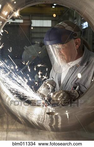Picture - Caucasian welder working on pipe. Fotosearch