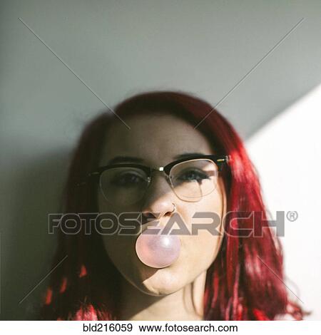 Stock Photo - Caucasian woman blowing bubble gum bubble. Fotosearch