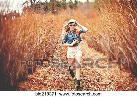 Caucasian woman carrying instant camera on dirt path View Large Photo Image Stock Image - Caucasian woman carrying instant camera on dirt path. Fotosearch