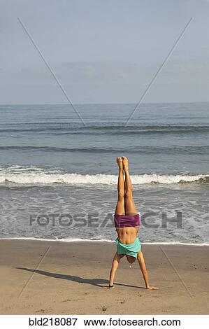 Caucasian woman doing handstand on beach View Large Photo Image Stock Photo - Caucasian woman doing handstand on beach. Fotosearch