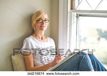 Caucasian woman drawing in windowsill View Large Photo Image Picture - Caucasian woman drawing in windowsill. Fotosearch