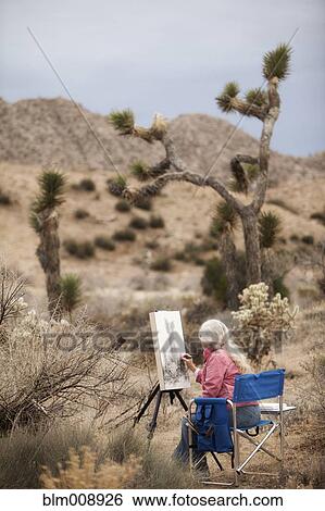 Caucasian woman drawing on easel outdoors View Large Photo Image Stock Photograph - Caucasian woman drawing on easel outdoors. Fotosearch