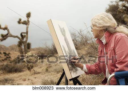 Stock Image - Caucasian woman drawing outdoors. Fotosearch