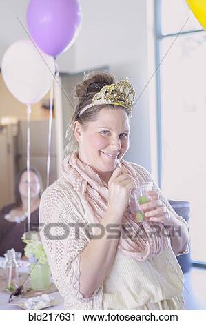 Stock Image - Caucasian woman drinking cocktail at party. Fotosearch