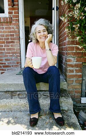 Caucasian woman drinking cup of coffee on front stoop View Large Photo Image Stock Image - Caucasian woman drinking cup of coffee on front stoop. Fotosearch