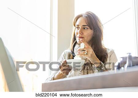 Picture - Caucasian woman drinking tea at table. Fotosearch