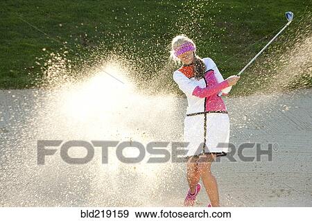 Caucasian woman hitting golf ball in sand trap while blindfolded View Large Photo Image Stock Photo - Caucasian woman hitting golf ball in sand trap while blindfolded. Fotosearch