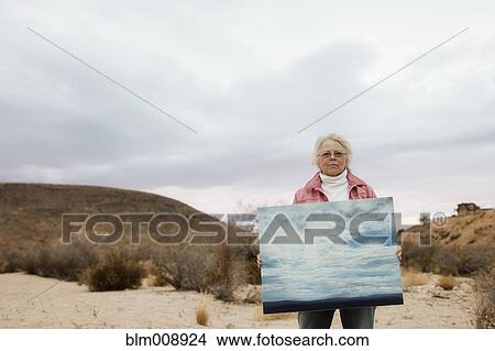 Caucasian woman holding painting outdoors View Large Photo Image Picture - Caucasian woman holding painting outdoors. Fotosearch