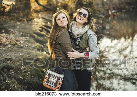 Stock Image - Caucasian woman hugging in park. Fotosearch