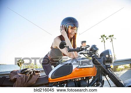 Stock Photography - Caucasian woman in helmet sitting on motorcycle. Fotosearch