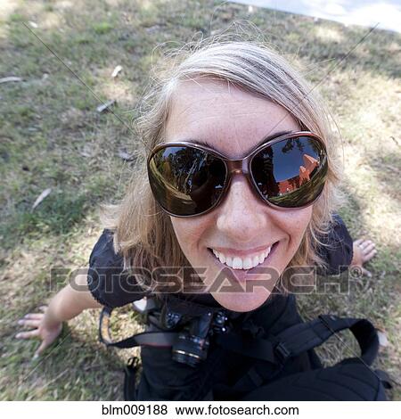 Caucasian woman in sunglasses holding camera View Large Photo Image Stock Photo - Caucasian woman in sunglasses holding camera. Fotosearch