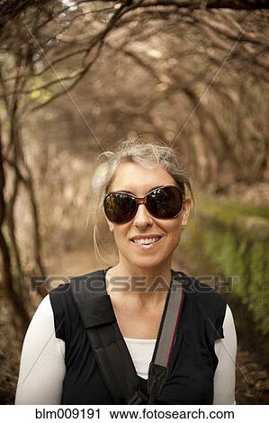 Caucasian woman in sunglasses standing outdoors View Large Photo Image Stock Image - Caucasian woman in sunglasses standing outdoors. Fotosearch