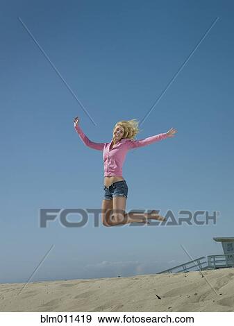 Caucasian woman jumping on beach View Large Photo Image Stock Photo - Caucasian woman jumping on beach. Fotosearch