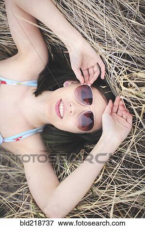 Stock Photo - Caucasian woman laying in hay. Fotosearch