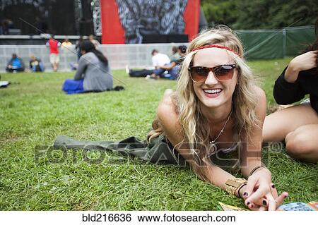 Stock Photograph - Caucasian woman laying in park grass. Fotosearch