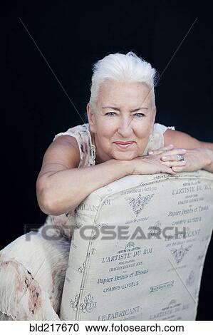 Stock Image - Caucasian woman leaning on chair back. Fotosearch