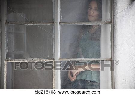 Stock Photo - Caucasian woman looking out window. Fotosearch