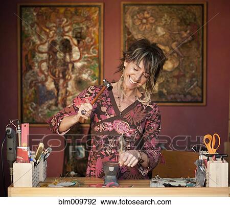 Stock Image - Caucasian woman making jewelry. Fotosearch
