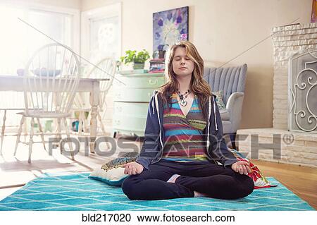 Caucasian woman meditating in living room View Large Photo Image Stock Image - Caucasian woman meditating in living room. Fotosearch