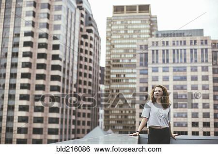 Caucasian woman on urban rooftop admiring cityscape View Large Photo Image Stock Photograph - Caucasian woman on urban rooftop admiring cityscape. Fotosearch