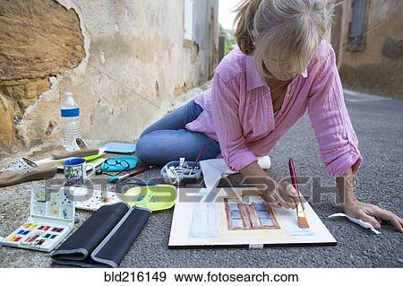 Caucasian woman painting on concrete ground View Large Photo Image Stock Photo - Caucasian woman painting on concrete ground. Fotosearch