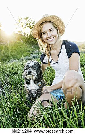 Caucasian woman petting dog in field View Large Photo Image Picture - Caucasian woman petting dog in field. Fotosearch