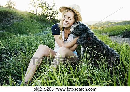 Caucasian woman petting dog in field View Large Photo Image Stock Photography - Caucasian woman petting dog in field. Fotosearch
