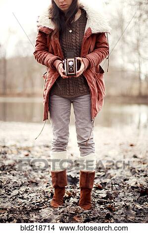 Caucasian woman photographing with vintage camera near rural pond View Large Photo Image Picture - Caucasian woman photographing with vintage camera near rural pond. Fotosearch