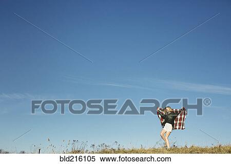 Stock Photography - Caucasian woman playing with scarf on hilltop. Fotosearch