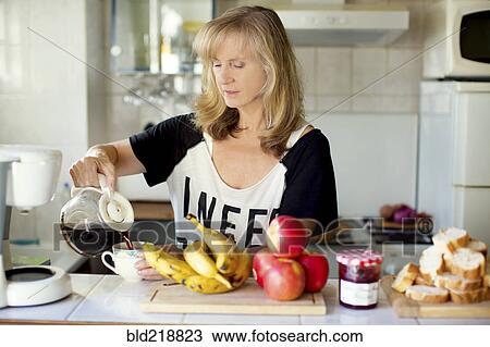 Caucasian woman pouring coffee in kitchen View Large Photo Image Stock Image - Caucasian woman pouring coffee in kitchen. Fotosearch