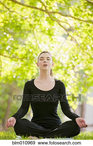 Caucasian woman practicing yoga in park View Large Photo Image Stock Photo - Caucasian woman practicing yoga in park. Fotosearch