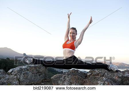 Stock Photo - Caucasian woman practicing yoga on mountaintop. Fotosearch