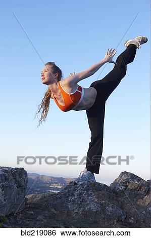 Stock Photograph - Caucasian woman practicing yoga on mountaintop. Fotosearch