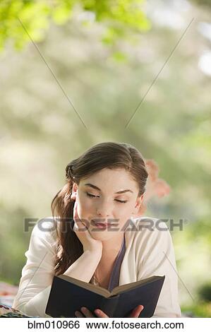 Caucasian woman reading book outdoors View Large Photo Image Stock Photograph - Caucasian woman reading book outdoors. Fotosearch