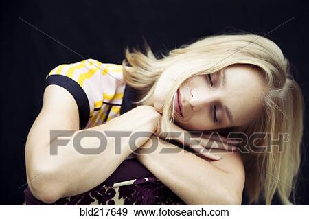 Stock Photo - Caucasian woman resting head on arms. Fotosearch