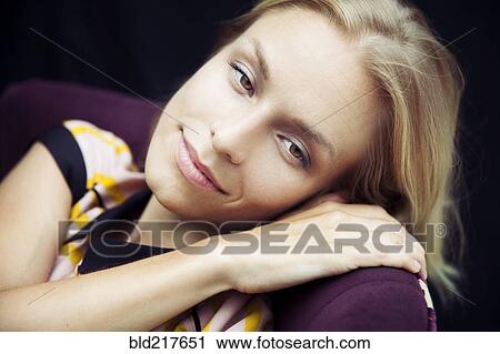 Stock Image - Caucasian woman resting head on chair. Fotosearch