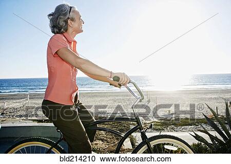Caucasian woman riding bicycle near beach View Large Photo Image Stock Image - Caucasian woman riding bicycle near beach. Fotosearch