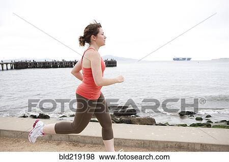 Caucasian woman running on waterfront View Large Photo Image Stock Photo - Caucasian woman running on waterfront. Fotosearch
