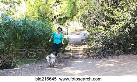 Caucasian woman running with dog on dirt path View Large Photo Image Stock Photography - Caucasian woman running with dog on dirt path. Fotosearch