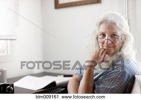 Stock Image - Caucasian woman sitting desk. Fotosearch