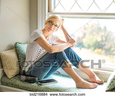 Caucasian woman sitting in windowsill View Large Photo Image Picture - Caucasian woman sitting in windowsill. Fotosearch