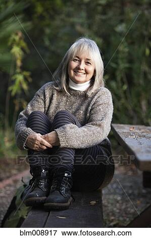 Caucasian woman sitting on picnic bench View Large Photo Image Stock Photo - Caucasian woman sitting on picnic bench. Fotosearch