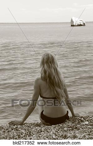 Caucasian woman sitting on rocky beach View Large Photo Image Stock Image - Caucasian woman sitting on rocky beach. Fotosearch